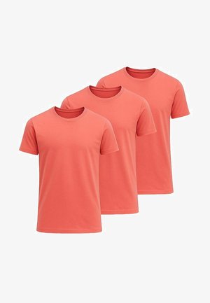 Sæt af tre T-shirts med rund hals i koralfarve, lavet af blød bomuld, med korte ærmer og et enkelt design uden mønstre eller detaljer.