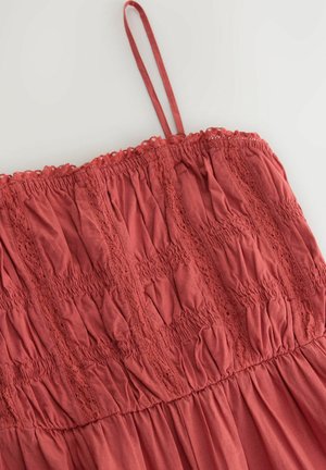 Röd bomullsklänning med skräddad tyg, spetsdetaljer och smala justerbara band, med en texturerad, samlad design.
