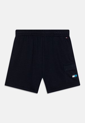 Schwarze lässige Shorts mit elastischem Bund, Seitentaschen und einer Klapptasche am rechten Bein, die mit einem kleinen farbigen Patch versehen ist.