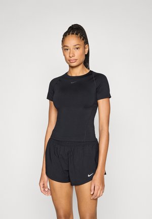 Top atletico nero con maniche corte e scollo rotondo, abbinato a pantaloncini neri con fascia elastica in vita e dettagli con logo Nike bianco.