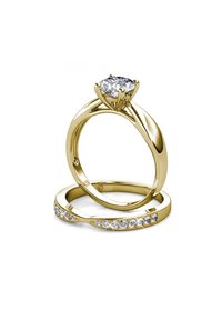 Anello di fidanzamento in oro con diamante tondo in un'impostazione a sei griffe, abbinato a una fede nuziale semplice decorata con piccole pietre rotonde.