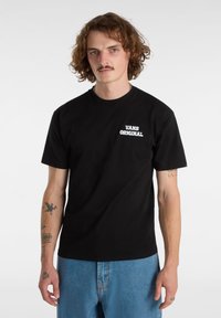 Camiseta de algodón negra con la inscripción "VANS ORIGINAL" en letras blancas en el lado izquierdo del pecho. Cuello redondo, mangas cortas, corte holgado.
