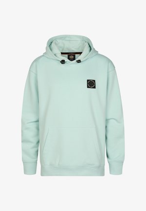 Hellblauer Kapuzenpullover mit Fronttasche und schwarzem Logo-Aufnäher, kombiniert mit blauen Jeans und weißen Sneakers, vor schlichtem Hintergrund stehend.