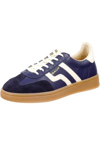 Scarpa atletica blu navy e bianca realizzata in pelle e camoscio, con suola in gomma testurizzata, chiusura con lacci e logo sul lato.