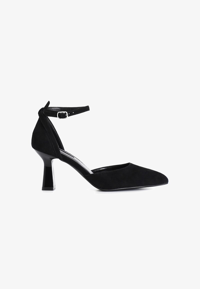 Black suede pump with a pointed toe, block heel, and ankle strap. Features a glossy accent on the heel and a smooth inner lining.