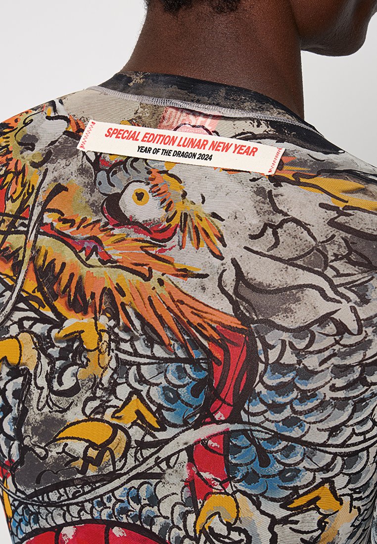 Kurzarmhemd mit einem bunten Drachen- und Phönix-Motiv auf strukturiertem Stoff, mit einem Etikett, das "Sonderausgabe zum Mondneujahr 2024" liest.