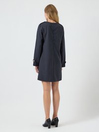 Μαύρο κομμένο φόρεμα με μακριά μανίκια, στρογγυλή λαιμόκοψη και λεπτομέρειες με κουμπιά στους καρπούς. Διαθέτει φερμουάρ στο πίσω μέρος και ευθεία σιλουέτα.