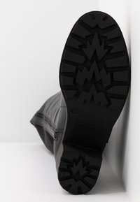 Semelle extérieure en caoutchouc noir avec traction à motif, couture latérale et logo de la marque. Tige de la botte avec une finition lisse et mate. Taille indiquée comme 37.