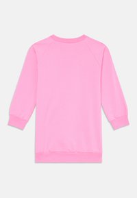 Sweatshirt rosa com mangas raglan longas, punhos elásticos e decote redondo. Feito de um tecido suave e liso. Sem gráficos visíveis.