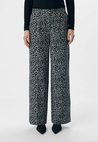 Wide-leg broek met een zwart-wit luipaardprint, gemaakt van een gladde stof met een platte tailleband en zijzakken.