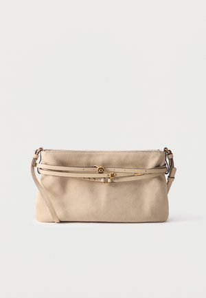 Sac à main en daim beige avec une fine bandoulière ajustable, deux fines ceintures décoratives et une boucle ainsi que des clous dorés sur le devant.