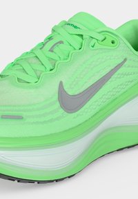 Φωτεινό νέον πράσινο παπούτσι τρεξίματος Nike με γκρι λογότυπο swoosh, επάνω μέρος από διαπνέον ύφασμα και παχύ μαξιλαρωμένο πέλμα με λευκές λεπτομέρειες στη μεσαία σόλα.
