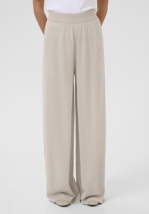 Beige wide-leg pants made of a soft, shimmery fabric with a high elastic waistband and side pockets. Smooth texture with a flowing design.