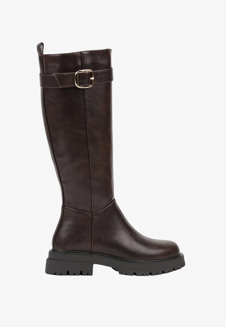 Botte en cuir marron jusqu'au genou avec un bout arrondi, semelle noire épaisse et accent de boucle métallique sur la tige. Texture lisse et design robuste.