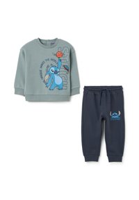 Twee-delige kinderoutfit: lichtgroen sweatshirt met blauwe Stitch graphic en tekst, gecombineerd met donkerblauwe sweatpants met trekkoord met Stitch.