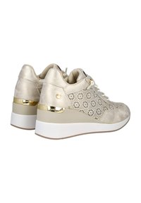 Zapatillas de cuña beige con detalles perforados, acentos metálicos y diseño con cordones. Textura suave y suela de goma blanca.