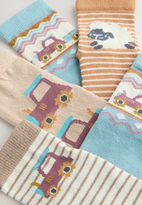 Cuatro pares de calcetines infantiles coloridos, con patrones de coches clásicos y ovejas sobre fondos a rayas y sólidos.
