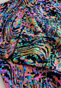 Țesătură cu model multicolor, cu forme vibrante roz, verde și albastru pe un fundal negru, având o suprafață netedă și texturată.