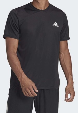 T-shirt de sport noir en tissu respirant. Il présente un col rond, des manches courtes et un logo Adidas blanc sur la poitrine gauche.