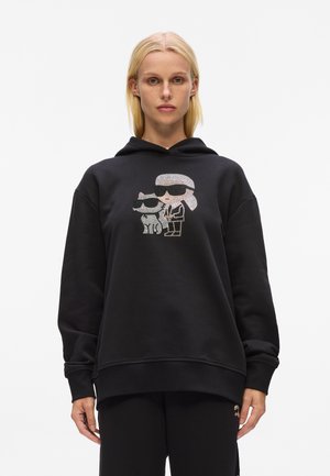 Felpa nera oversize con un design grafico di due personaggi con occhiali da sole, realizzata in morbido tessuto misto cotone.