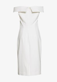 Robe blanche à épaules dénudées avec un corsage ajusté et une jupe crayon, présentant une texture lisse et une fermeture éclair au dos.
