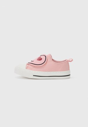 Pink canvas slip-on shoe with a white rubber toe cap, featuring a large black and pink heart design on the side, and a pull tab at the back.