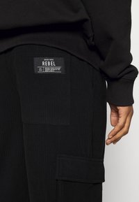 Redefined Rebel ARCHER PANTS UNISEX  - Calças de fato de treino - black