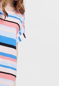 T-shirt à manches courtes avec des rayures horizontales en rose, bleu et noir. Tissu doux avec une coupe décontractée et un col rond.