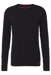Maglione nero a maniche lunghe con collo a giro e cuciture rosse lungo le cuciture delle spalle, e un piccolo tag metallico del marchio all'orlo inferiore.