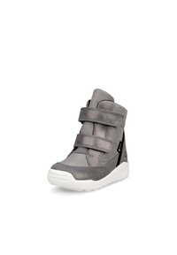 Grå ankelsko med två velcro-remmar, kontrasterande svart accent på sidan och en vit gummisula. Texturerad tyg och släta paneler.