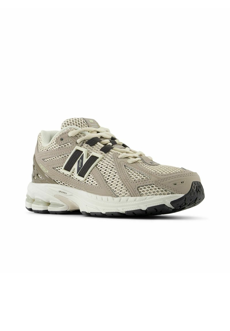 Scarpa da corsa in mesh beige con punta rinforzata, dettagli neri e suola testurizzata. Presenta una intersuola ammortizzata e un design con lacci.