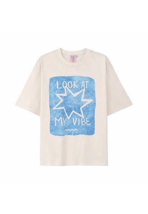 Beżowy T-shirt z krótkim rękawem z niebieskim kwadratem przedstawiającym uśmiechającą się gwiazdę i napisem "PATRZ NA MÓJ VIBE" z przodu.