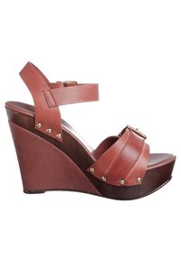 Sandale compensée en cuir marron avec des larges brides et des accents en métal doré ; plateforme imitant le bois avec une finition lisse ; design à dos ouvert.