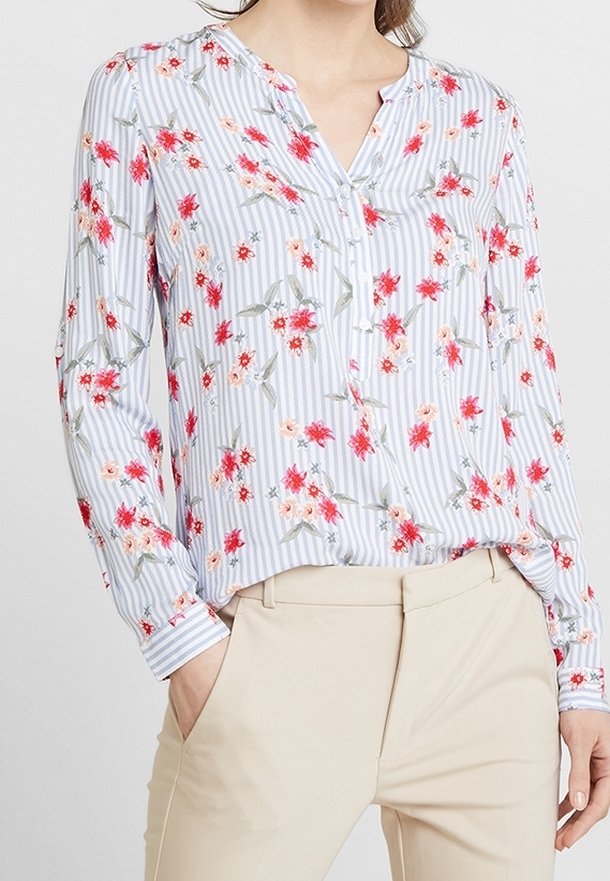 Blus med blommönster i blå och vita ränder, långa ärmar, v-ringad halslinje och knappdetalj. Tyget verkar lätt och mjukt.
