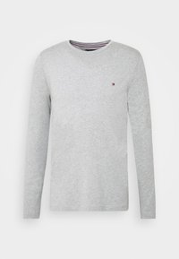 Svetr s dlouhým rukávem šedé barvy, kulatý výstřih, minimální značení na prsou, měkká textura a rovný střih, vhodný pro volnočasové nošení.