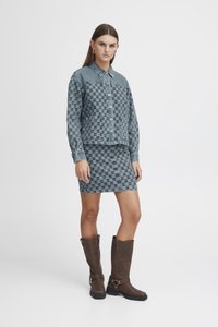 Denim jakna in krilo v modrem šahovskem vzorcu, z gumbi, dolgimi rokavi in ovratnikom. V kombinaciji s krošnjarji do kolen v rjavi barvi.
