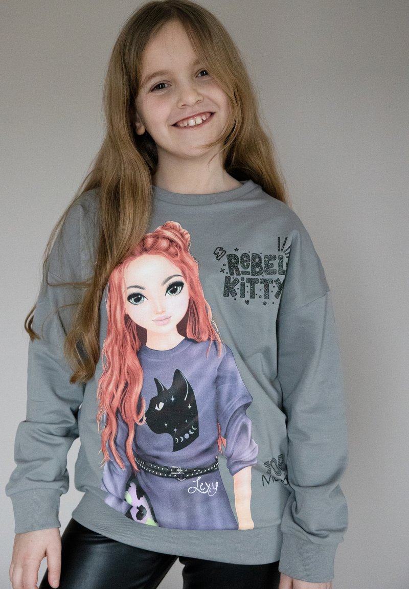 Felpa grigia con una stampa grafica di una ragazza dai lunghi capelli rossi e un gatto nero, impreziosita dal testo "Rebel Kitty" e da un dettaglio a cintura.