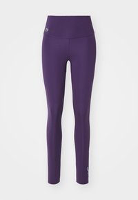 Lilla trenings leggings har høy midje, glatt tekstur og logo detalj nær ankelen. Designet for komfort og bevegelse.