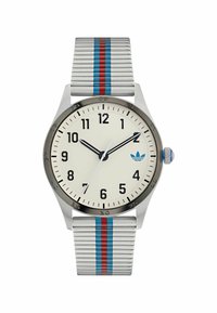 Sidabrinis analoginis laikrodis su balta ciferblatu, juodais valandų žymekliais ir mėlynu logotipu. Yra dryžuota sidabrinė apyrankė su raudonais ir mėlynais akcentais.
