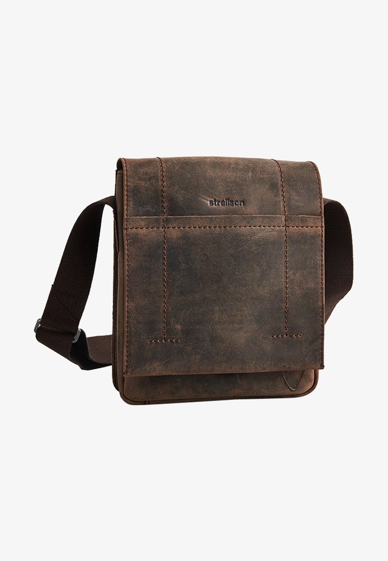 Brun læder messenger taske med klaplukning, justerbar stofrem, synlige sømdetaljer og præget logo på forsiden.