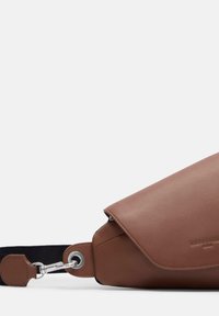 Braune Leder-Umhängetasche mit Klappenverschluss, silberfarbener Hardware, strukturiertem Finish und kontrastierendem schwarzen Tragegurt.