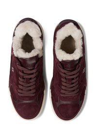 Bordowe zamszowe trampki z futrzanym wyściełaniem, zaokrąglonym noskiem i gumową podeszwą. Posiadają brązowe akcenty oraz sznurowanie.