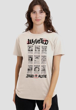 Woman wearing beige T-shirt with nine black-and-white wanted posters arranged in three rows, text "WANTED DEAD OR ALIVE" below.