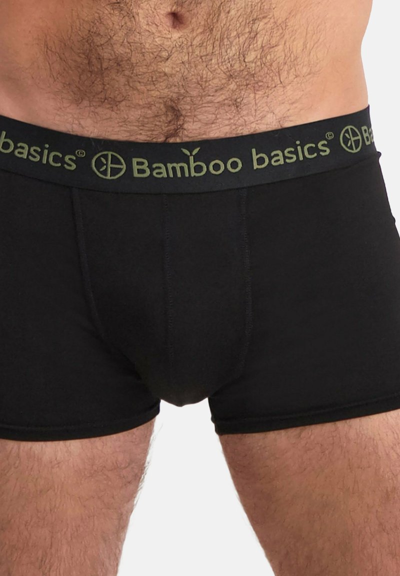 Boxers en bambou noir avec une ceinture verte arborant le logo "Bamboo basics". Texture lisse, design ajusté et longueur mi-cuisse.