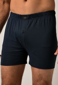 Boxer shorts di un blu navy scuro realizzati in tessuto morbido, con una vita elastica e un'apertura con un singolo bottone. Design semplice con una superficie liscia.