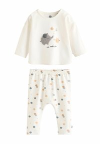 Ensemble en coton composé d'un haut à manches longues crème avec un éléphant brodé et d'un pantalon beige à pois colorés.