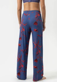 Wijde broek in blauwe stof met een bloemenpatroon in rood. Zachte textuur met een elastische tailleband, geschikt voor casual wear.