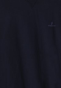 Suéter de cuello en V azul marino hecho de tela suave y texturizada, con un sutil logo "Freddy" en un tono más oscuro en el lado izquierdo.