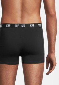 Zwarte katoenen boxershorts met een brede elastische tailleband waarop "CR7" in het wit staat. De snit is aansluitend, met een gladde afwerking en minimale naden.