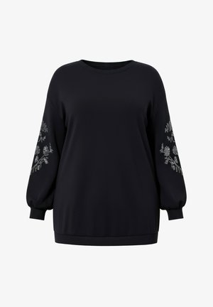 Musta pitkähihainen paita, jossa pyöreä pääntie ja hopeiset kukkakuvioiset strassikuviot molemmissa hihoissa.